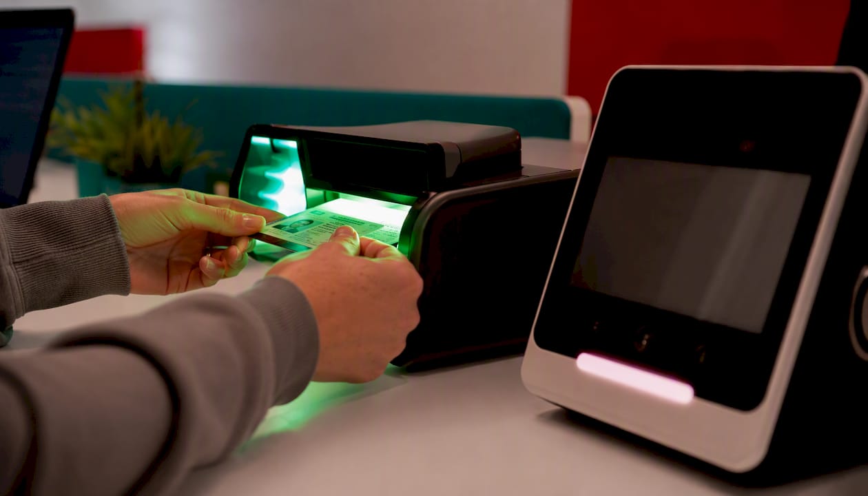 Hands scanning ID card under blue light