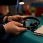 Hands placing headset on desk at night shift