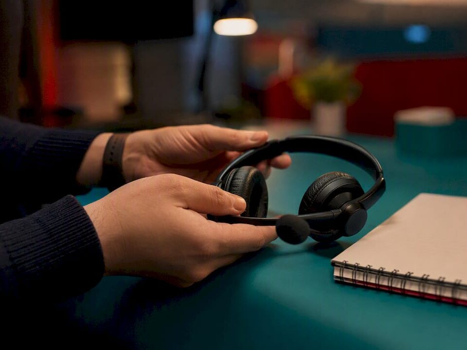 Hands placing headset on desk at night shift