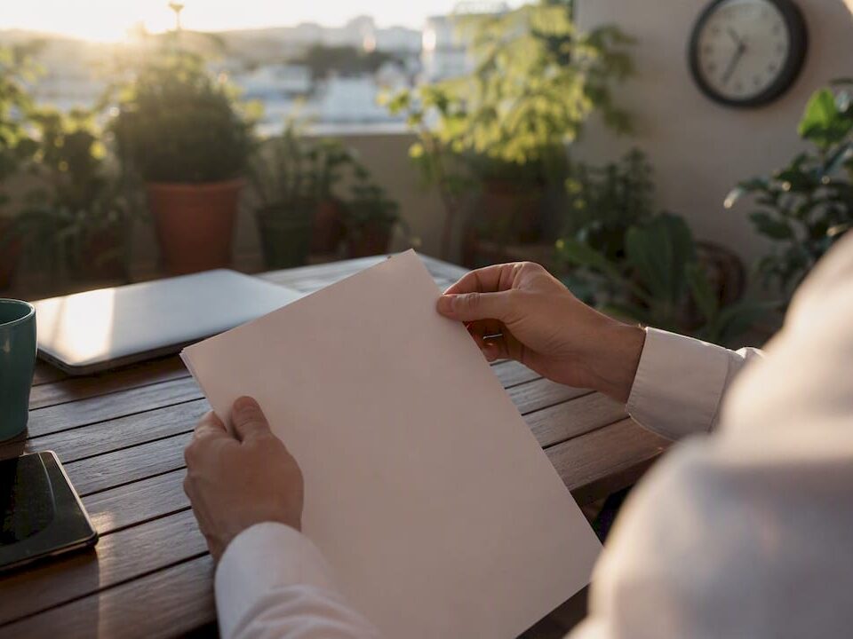 Hands holding contract paper edge on desk